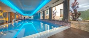 ein Schwimmbad in einem Hotel mit blauer Decke in der Unterkunft Hotel Belvedere in Braşov