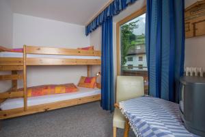 a bedroom with two bunk beds and a window at Pension Anneliese in Rauris