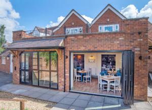 an extension to a brick house with a patio at Chequers Inn in Fladbury