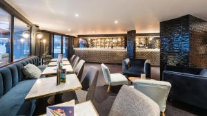 een restaurant met tafels en stoelen en een bar bij Fahrenheit Seven Courchevel in Courchevel