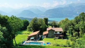 a house on a hill with a swimming pool and mountains at Tenuta Pozzi in Colico