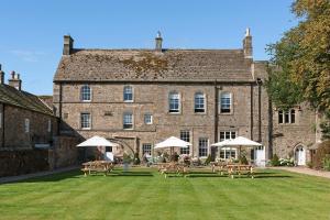a large brick building with tables and umbrellas in front of it at Lord Crewe Arms Blanchland in Blanchland