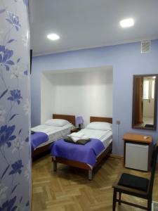 a room with two beds and a table and a mirror at Tbilisi Downtown Guest House in Tbilisi City