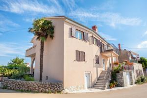 budynek z palmą przed nim w obiekcie Holiday apartment IVICA w mieście Milohnići