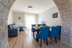 uma sala de estar com uma mesa e cadeiras azuis em Holiday apartment IVICA em Milohnići