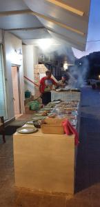 two men preparing food on a counter in a restaurant at Andreas Apartments in Kefalos