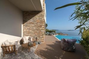 Un patio con sillas y una mesa y una piscina. en Villa K, en Skiathos