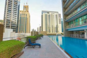 a swimming pool in a building with benches and buildings at Prime Retreats - Downtown Dubai in Dubai