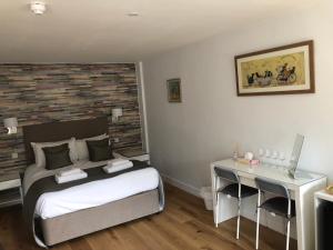 a bedroom with a bed and a desk in it at Hamilton Arms in Midhurst