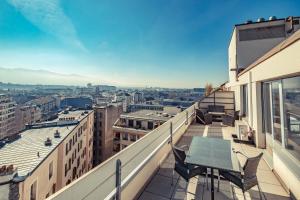 einen Balkon mit einem Tisch und Stühlen auf einem Gebäude in der Unterkunft Starling Hôtel Résidence Genève in Genf