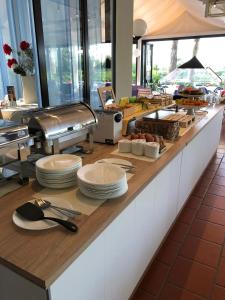 a buffet line with plates and utensils in a restaurant at Hotel King in Lido di Jesolo