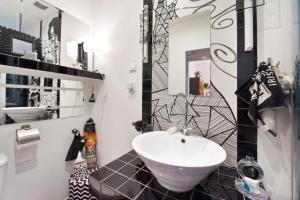 a bathroom with a sink and black and white tiles at Studio Lawendowa in Gdańsk