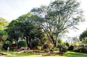 a park with trees and a playground in the grass at The Manderson Hotel and Conference Centre in Stutterheim