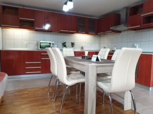 a kitchen with a wooden table and white chairs at Crystal Salin in Turda