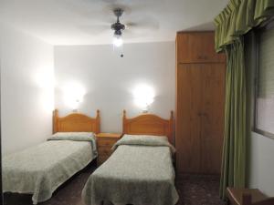 two beds in a room with at Pension Americano in Almería