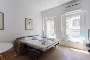 een slaapkamer met een bed en 2 ramen bij Meravigli 16 - Apt B - Duomo Elegant Apartment! Self Check-In in Milaan