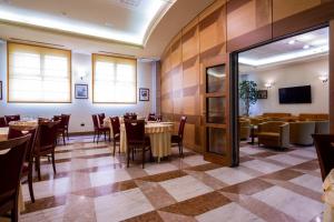 Hotel Persico's في سان جوفاني في برسيتشتو: غرفة طعام مع طاولات وكراسي وتلفزيون