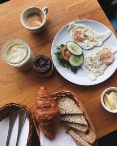 a table with a plate of breakfast food with eggs and bread at Hostel Przy Targu Rybnym in Gdańsk