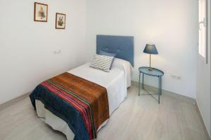 een slaapkamer met een bed en een blauwe tafel bij La Merced RooMalaga by Bossh! Apartments in Málaga
