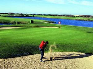a man is standing on a golf course at Luxury Apartment, 3 min Walk to Beach, Albufeira in Guia