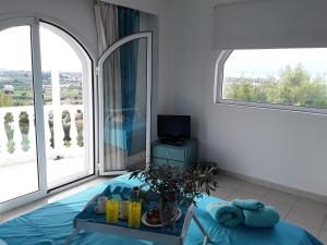 een slaapkamer met een bed en een groot raam bij Heavenly Views-1- Maisonette with pool close to the Beach in Oropos