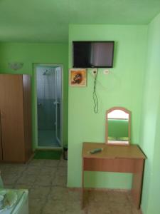 a bathroom with a shower and a table and a mirror at Guest House Pepina in Sozopol