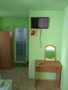 ein Bad mit einer Dusche, einem Tisch und einem Spiegel in der Unterkunft Guest House Pepina in Sozopol