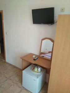 a room with a desk and a television on a wall at Guest House Pepina in Sozopol