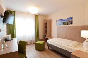 Habitación de hotel con cama y escritorio en City-Hotel Kurfürst Balduin, en Coblenza