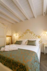Un dormitorio con una cama grande con un cabecero grande. en Ca' Vittoria Boutique House ApartSuite Chioggia, en Chioggia
