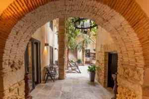 łuk w budynku ze stołem i krzesłami w obiekcie Hotel Boutique V w mieście Vejer de la Frontera