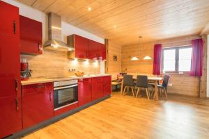 a kitchen with red cabinets and a table with chairs at Landhaus Panorama in Bad Hindelang +11 photos