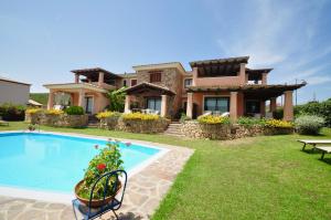 a house with a swimming pool in front of a house at Le Dimore di Nettuno - Happy Rentals in Olbia