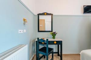 een blauwe kamer met een tafel en een spiegel bij Phaedra Hotel in Athene