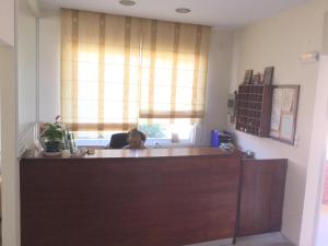 a person sitting at a desk in a office at Hotel Kallithea in Loutra Edipsou