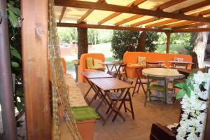 een patio met tafels en stoelen onder een houten pergola bij Casa Fogli Casa Vacance & Events in Campiglia Marittima