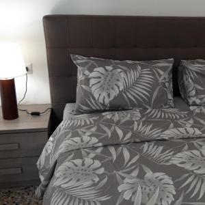 米蘭的住宿－G&A Milan House CIR 03041，一张带灰色和白色棉被和枕头的床