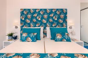 a bedroom with a bed with blue and white pillows at Gala Residence Villa Giovanna in Ravello
