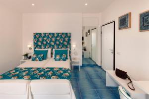 a bedroom with two beds and a blue floor at Gala Residence Villa Giovanna in Ravello