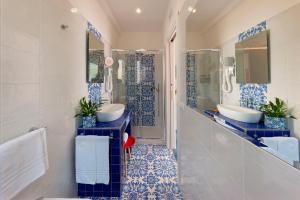 a bathroom with two sinks and blue and white tiles at Gala Residence Villa Giovanna in Ravello