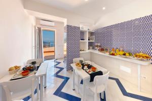 Gala Residence Villa Giovanna في رافيلو: مطبخ وغرفة طعام مع طاولة وكراسي