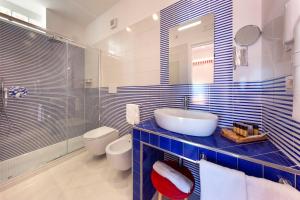 a bathroom with a sink and a toilet and a mirror at Gala Residence Villa Giovanna in Ravello