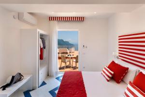 a bedroom with a red and white bed and a table at Gala Residence Villa Giovanna in Ravello