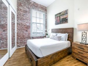 een slaapkamer met een bed en een bakstenen muur bij Spacious Condos close to Art & Culture NOLA in New Orleans