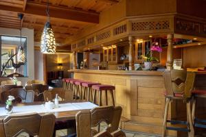 a restaurant with a bar with tables and chairs at Hotel Kaiserhof in Medebach