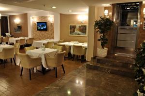 a dining room with white tables and chairs at Hotel Edirne Palace in Edirne