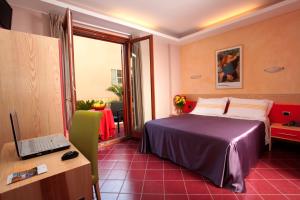 una camera d'albergo con letto e scrivania con computer portatile di Hotel Diana a Pompei