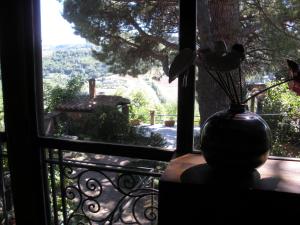 un jarrón con flores sentado en una mesa mirando por la ventana en B&B Ippolito, en Orvieto