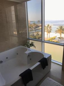 a bath tub in a bathroom with a large window at Ilica Hotel Spa & Wellness Resort in Çeşme