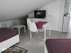 um quarto com uma secretária, uma cama, uma mesa e cadeiras em B&B Residenza Leonardo em Falconara Marittima